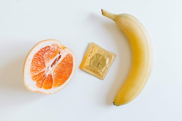 An orange, condom, and banana show the concept of sexual wellness - My Medical Training An orange, condom, and banana show the concept of sexual wellness